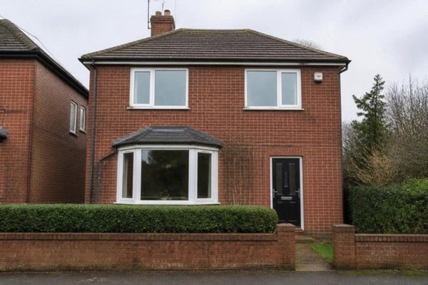 Illustration: a red-brick detached house with white uPVC windows and a bay window