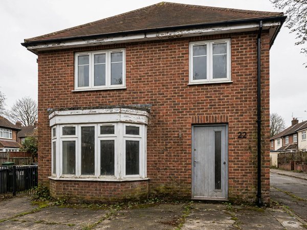 An example detached brick house with tired white window frames