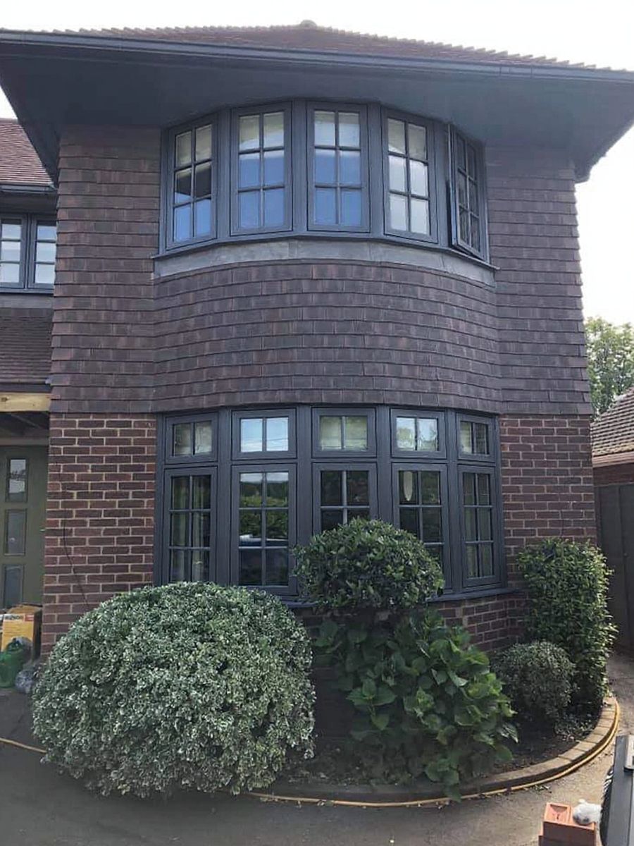 A bay-fronted brick home after its window frames were recoloured anthracite
