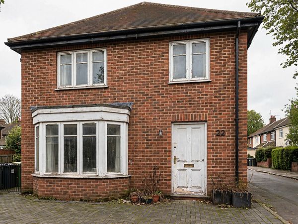 Illustration: a brick house with old white windows and a worn white front door
