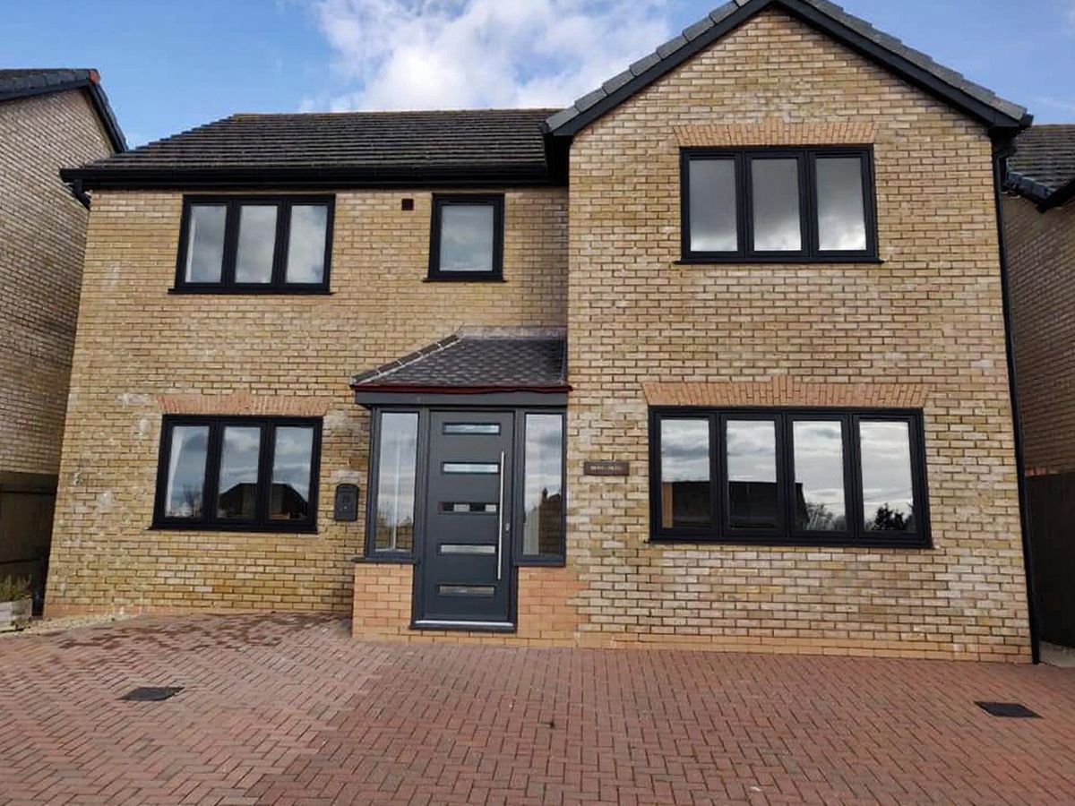 A modern yellow-brick detached home after its frames were recoloured anthracite
