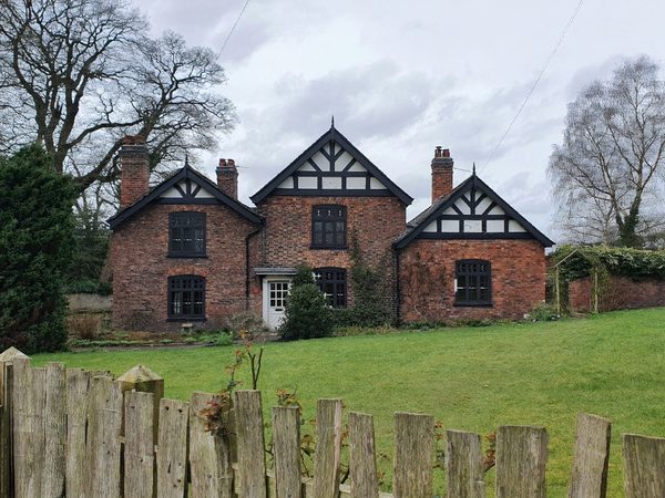 AI visualisation: the same house with anthracite uPVC casement windows, glazing bars kept, white front door unchanged